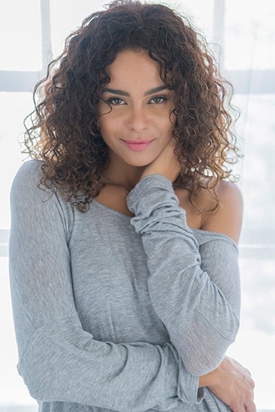 Backlit boudoir image of mixed race woman in stretchy top