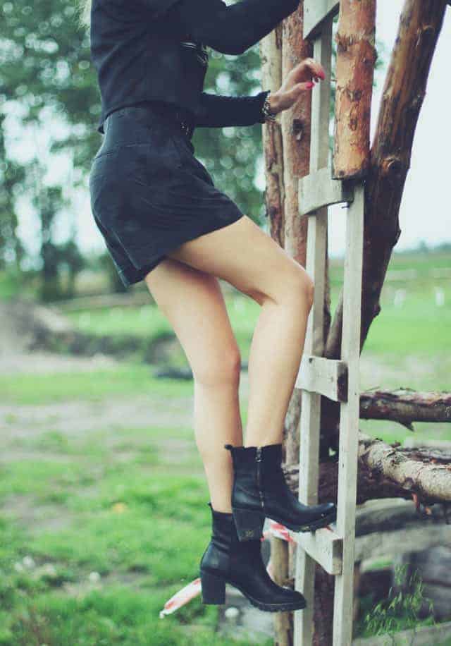 Woman in short skirt climbing treehouse ladder