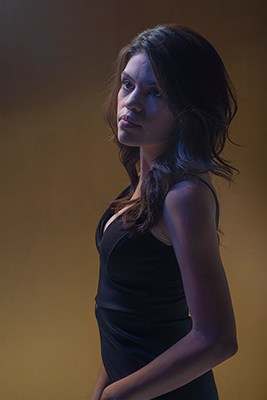 Moody portrait of young woman with blue hue.