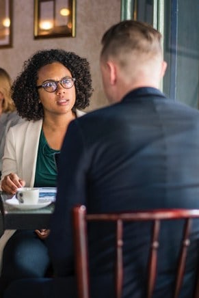 Woman receiving bad news from man in cafe