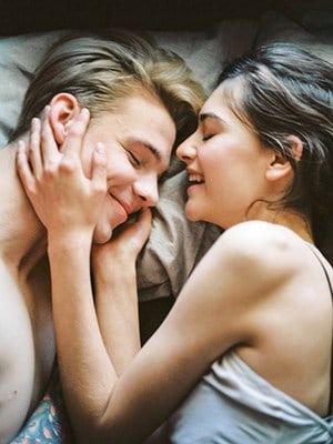 Young white couple lying in bed