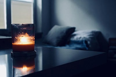 Orange candle in blue bedroom