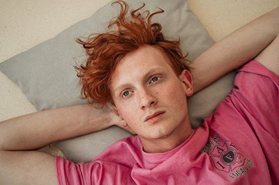 Red-headed young man in pink shirt