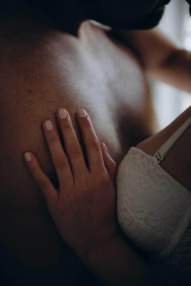 Woman's hand on man's bare chest