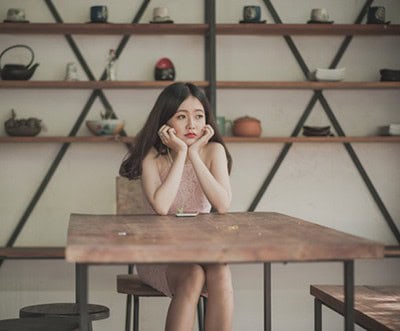 Bored Asian girl waiting at table