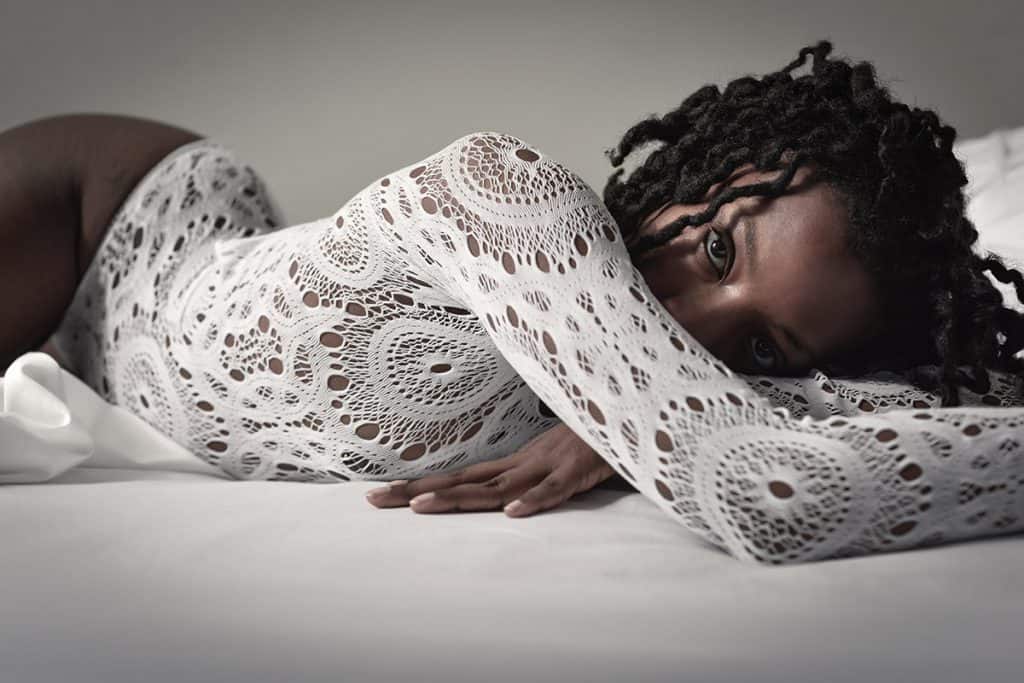 Boudoir bed pose on stomach