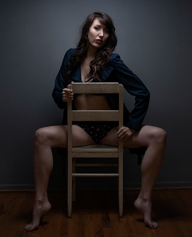 Boudoir chair pose with woman straddling chair
