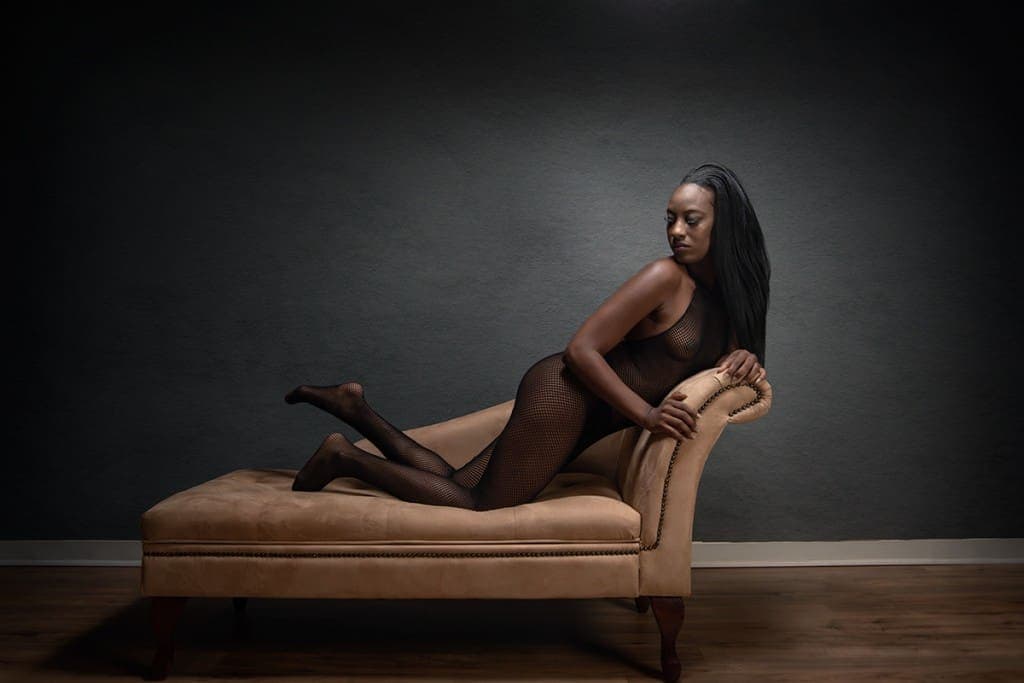 Kneeling boudoir pose on chaise lounge